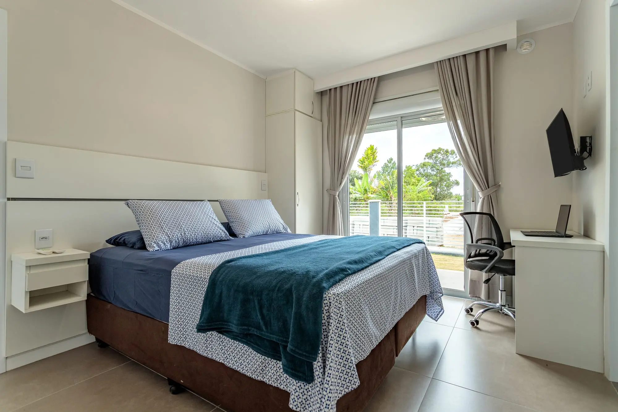 Suíte com cama de casal e espaço de trabalho